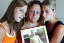 Fond memories: sisters Stacy and Michele comfort their mother, Kim Beer  holding a photograph of Phil  on the first anniversary of his death	