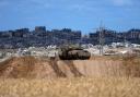 An Israeli tank overlooks the Gaza Strip (Tsafrir Abayov/AP)