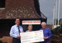 Store manager Paul Stephens presenting the cheque to volunteers Carol Stewart and Colin Ringham