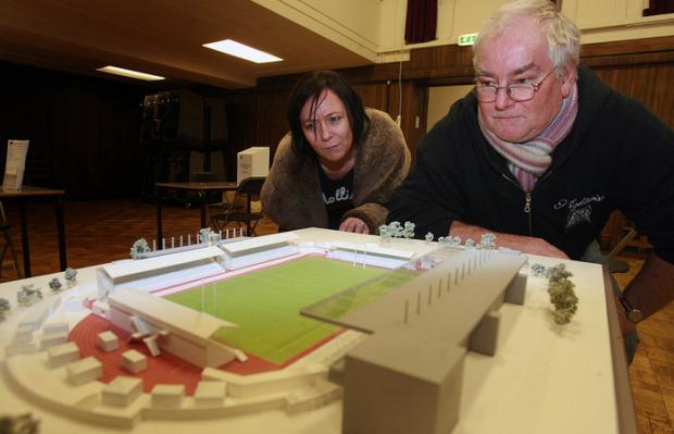 Debora Donner and Nick German looking at a model of the stadium.