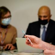 Health Secretary Sajid Javid helps fill in patient data during a visit to Abbey vaccine centre in central London. Photo: PA