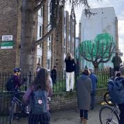 People gather in front of the potential Banksy earlier today (March 18)