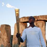 Michael Johnson with the Olympic torch at Stonehenge. Picture: Action Images