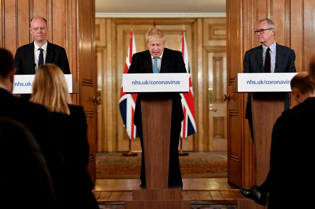 Chief Medical Officer Professor Chris Whitty (left) and Chief Scientific Adviser Patrick Vallance (right) watch as Prime Minister Boris Johnson at the news conference inside 10 Downing Street, London