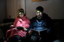Moda Todorova (left) and her husband Chavdar (right) use head torches as lights to cut down their electricity bill