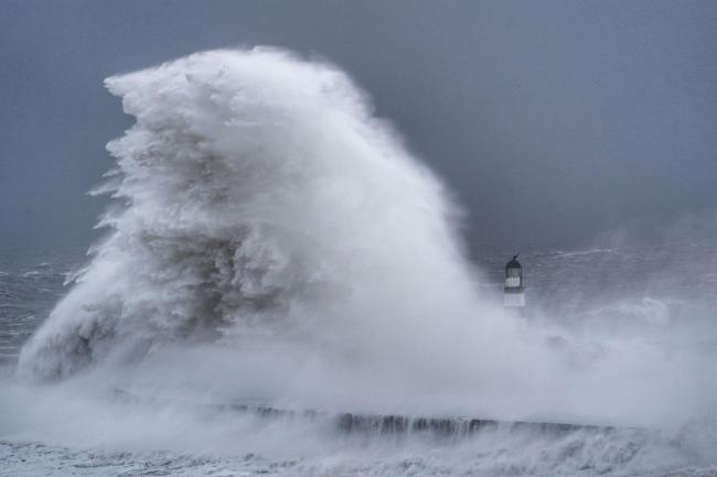 Huge waves crash against the lighthouse in Seaham Harbour, County Durham