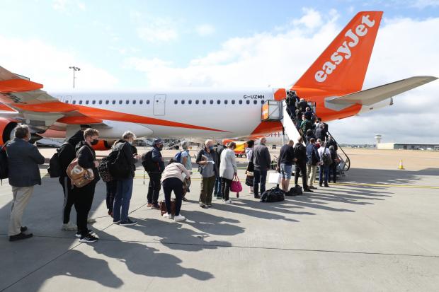 Times Series: People queue to board an EasyJet plane. (PA)
