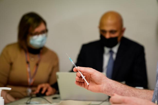 Health Secretary Sajid Javid helps fill in patient data during a visit to Abbey vaccine centre in central London. Photo: PA