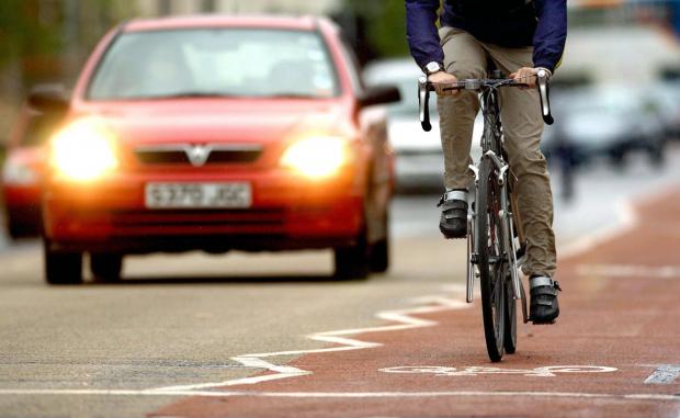 Times Series: Photo via PA shows a cyclist on the road near traffic.