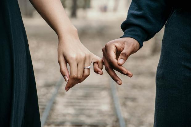 Serie Times: Una pareja entrelazando los dedos mientras ella lleva un anillo de compromiso.  Cru00e9dito: canva