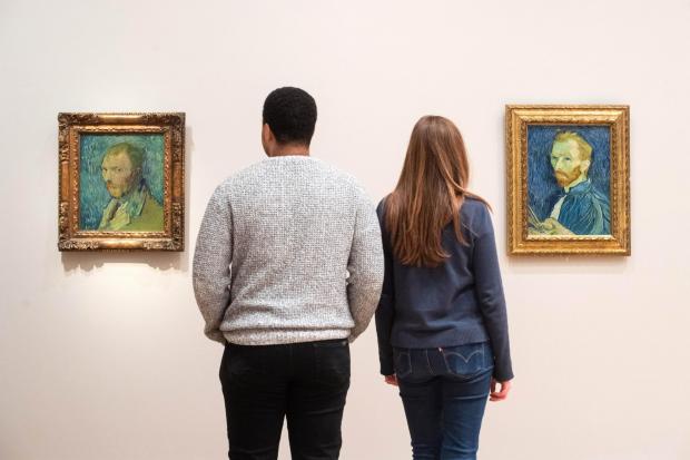 Courtauld staff member Aaron Stennett and Amy Graves view two of Vincent Van Gogh's self-portraits, both titled 'Self-Portrait' are hung side-by-side at the Courtauld Gallery in London (PA)