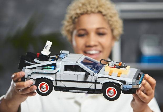 Times Series: A woman holding the LEGO Back to The Future Delorean set. Credit: LEGO