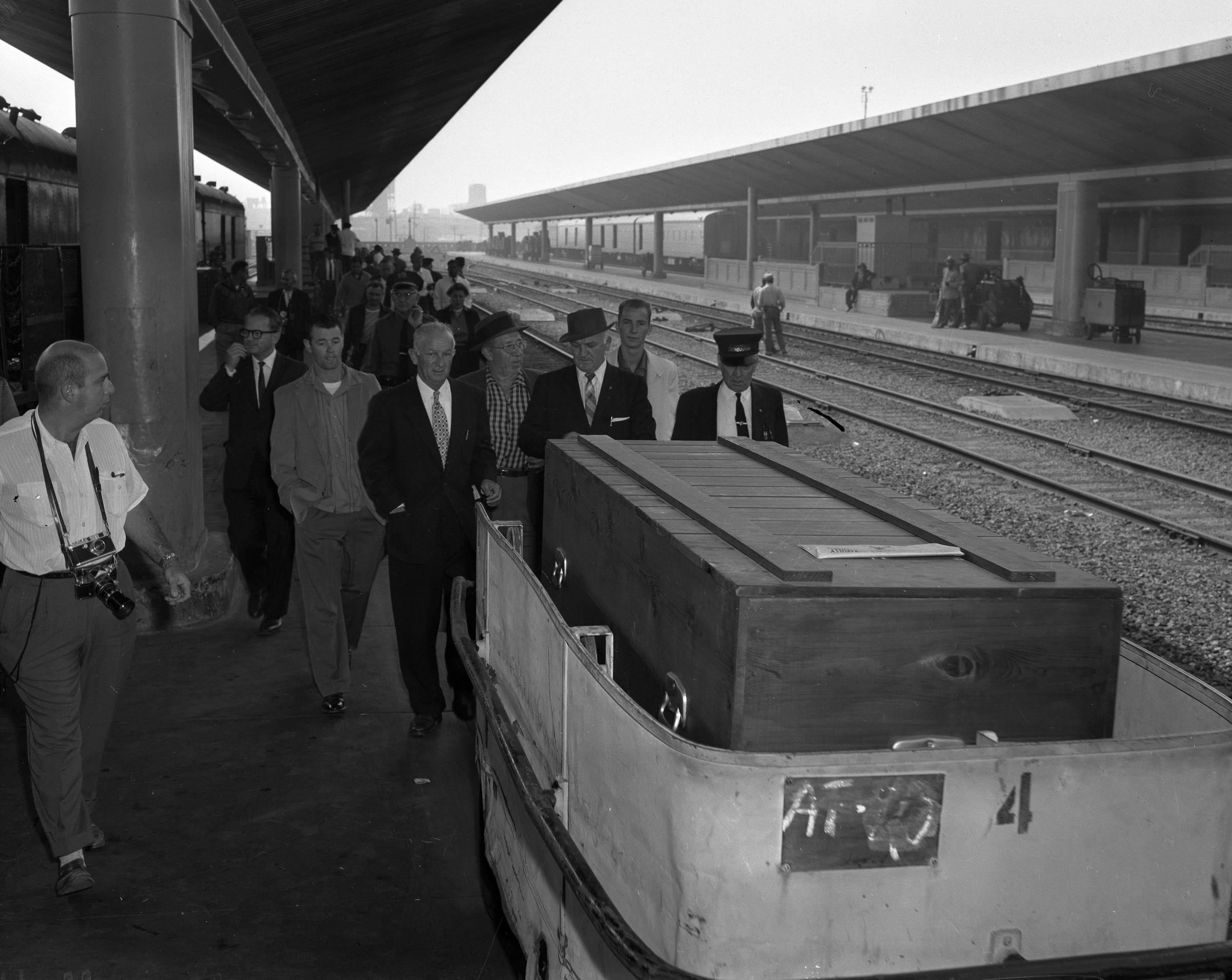 Cercueil d'Errol Flynns sur le quai de la gare Union de Los Angeles en 1959. En costume sombre et chapeau derrière le cercueil se trouve Buster Wiles, double et ami de Flynns.  Photo : archives du Los Angeles Times