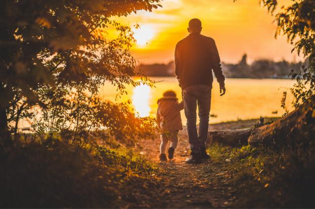 Times Series: Father and child walking together at sunset. Credit: Canva