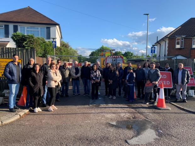 Times Series: Residents want Pike Road, pictured behind them, reopened by TfL. The street is being used to store maintenance vehicles involved in the bridge repairs